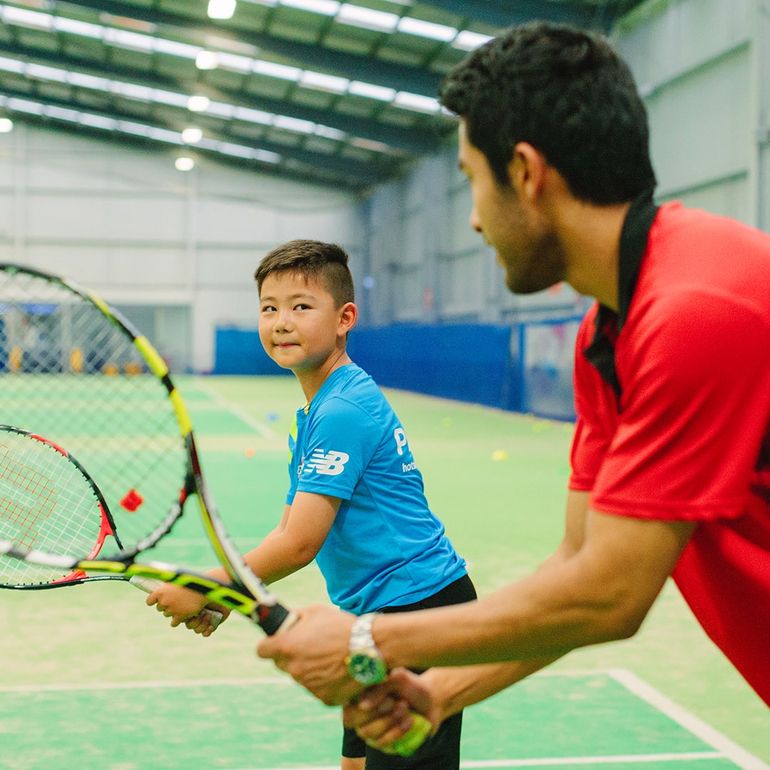 Child getting a tennis lesson