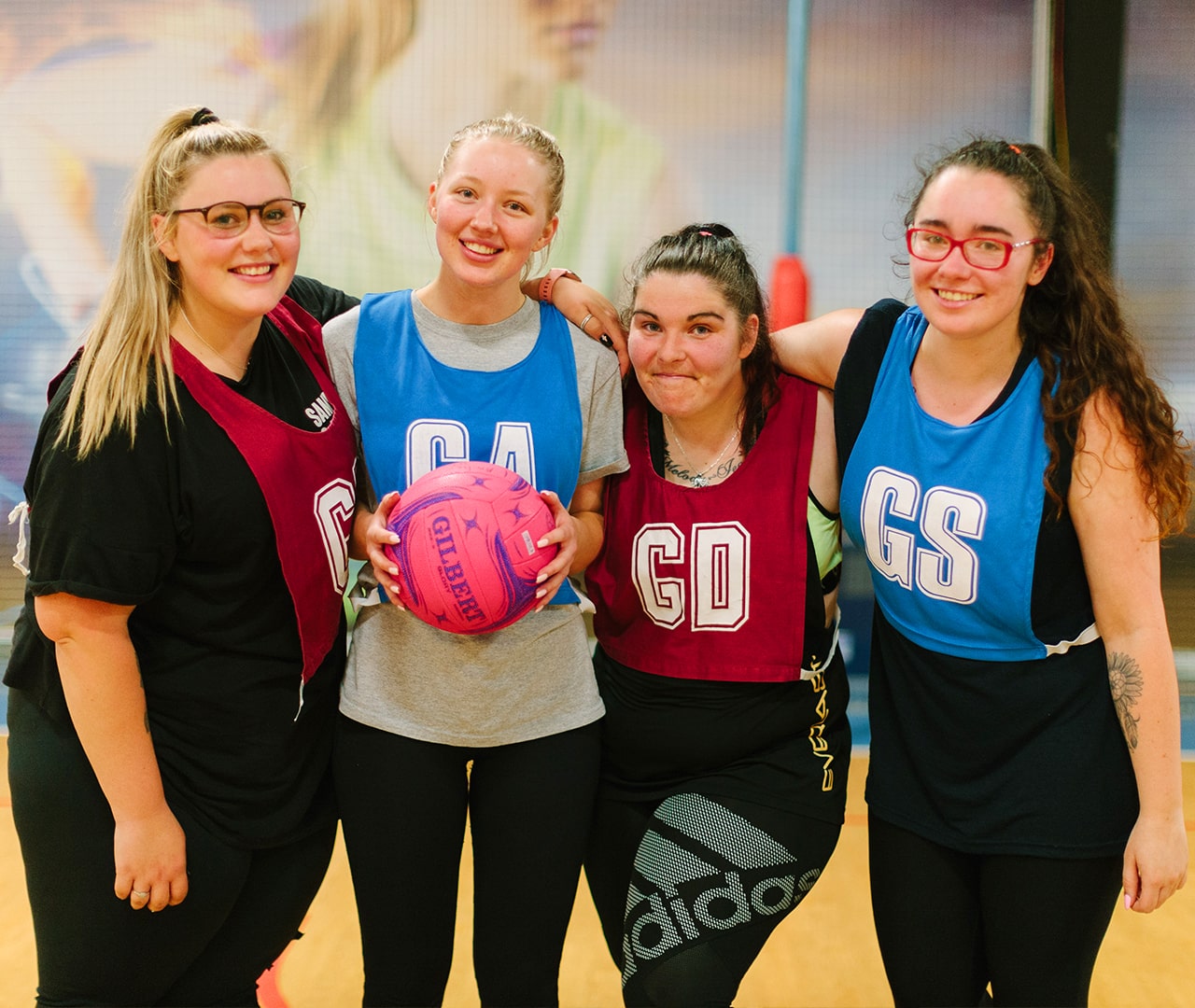 Four adult netballers smiling for the camera