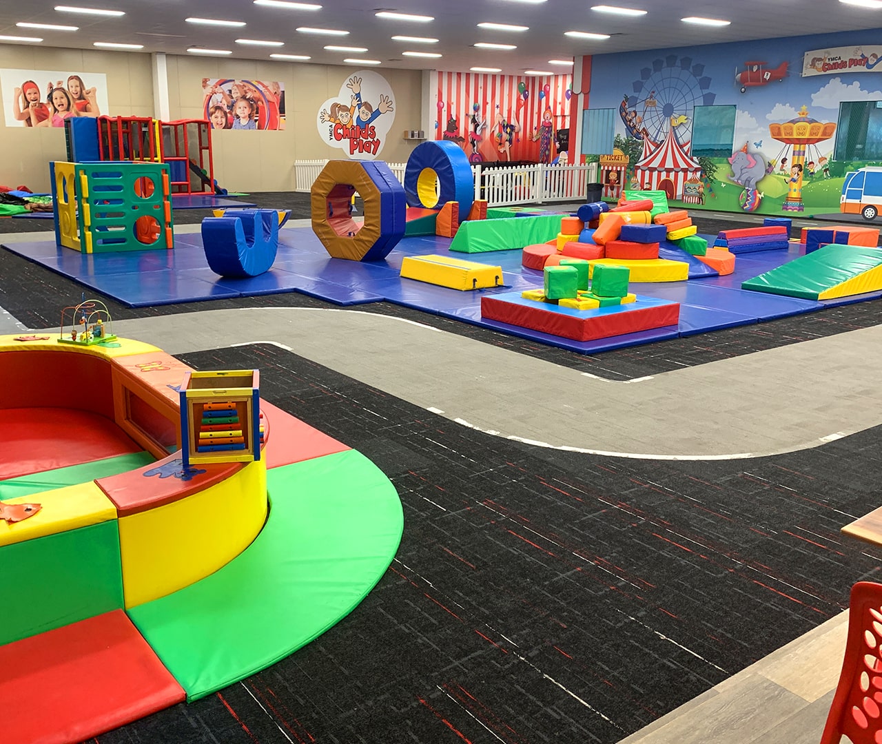 Large, colourful children's indoor play area with lots of equipment