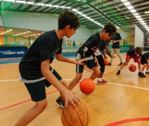 Young people practising dribbling a basketball