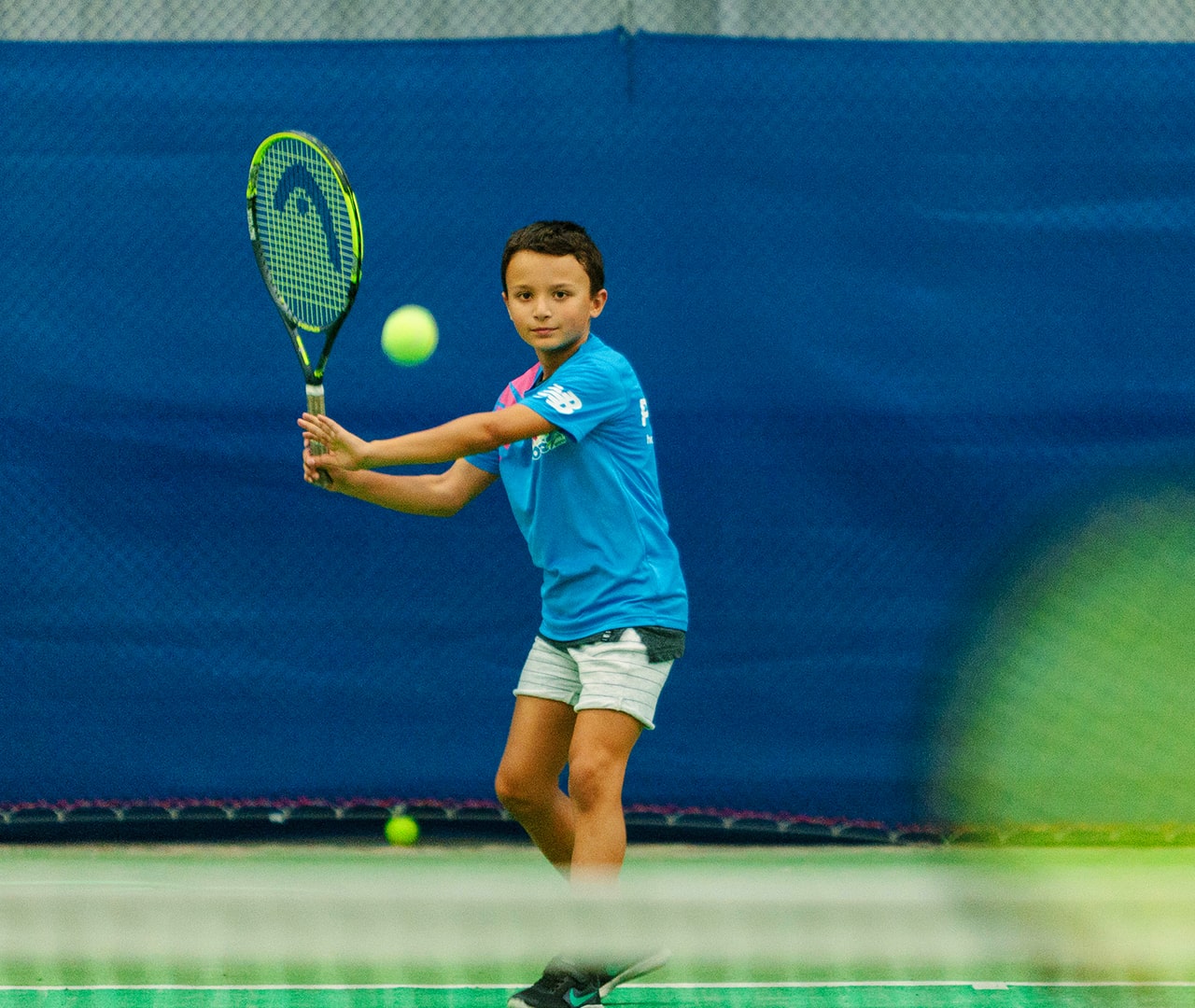 Young tennis player on the court about to hit a ball with their racquet