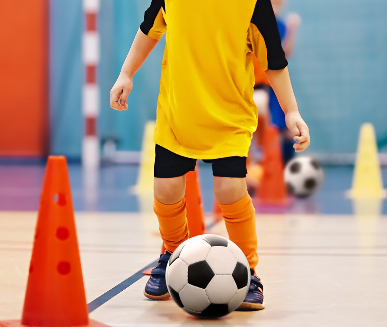 Child, soccer ball and cones, indoors