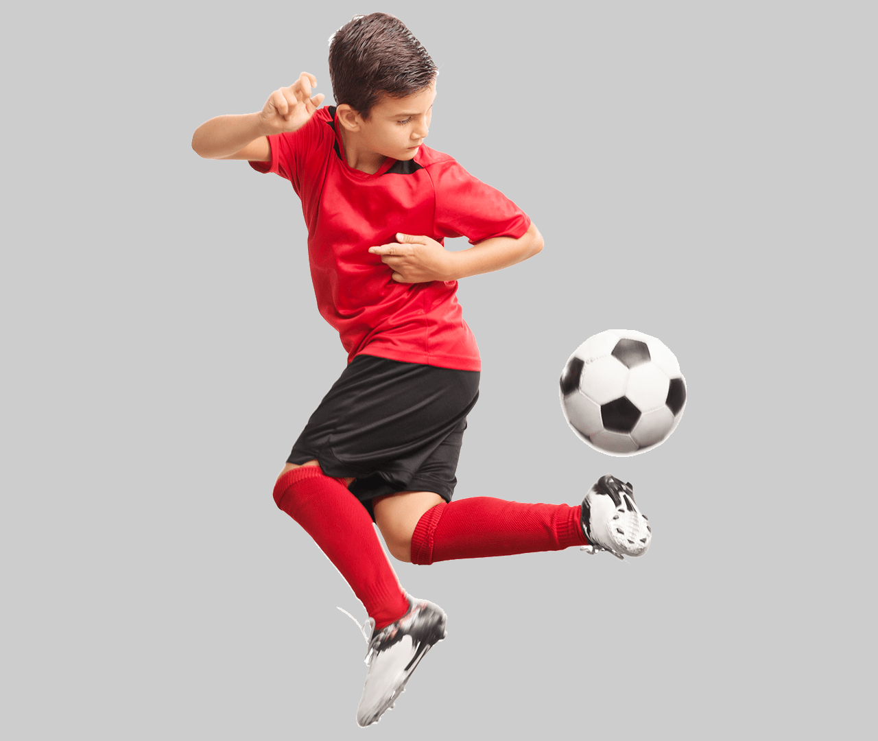 Boy jumping in the air and using his heel to kick the soccer ball, with a blank background